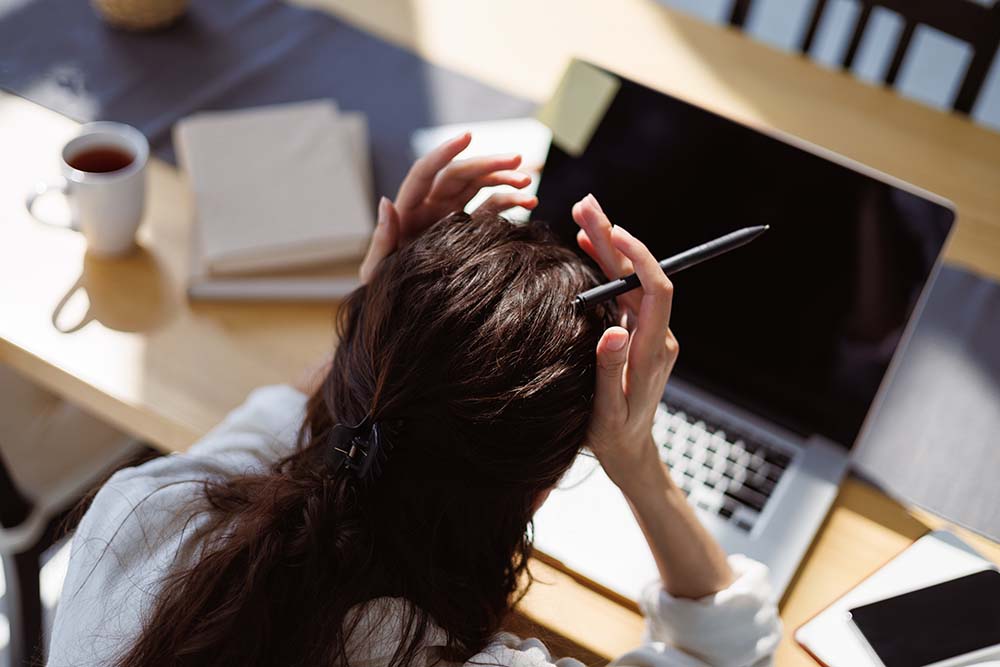 Exhausted professional at a desk in a Singapore office, representing workplace burnout among employees in 2026